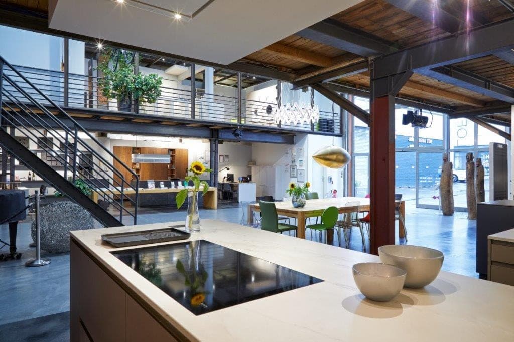 Kücheninsel mit bündig eingelassenem Kochfeld in einem Loft — über der Insel hängt keine Haube