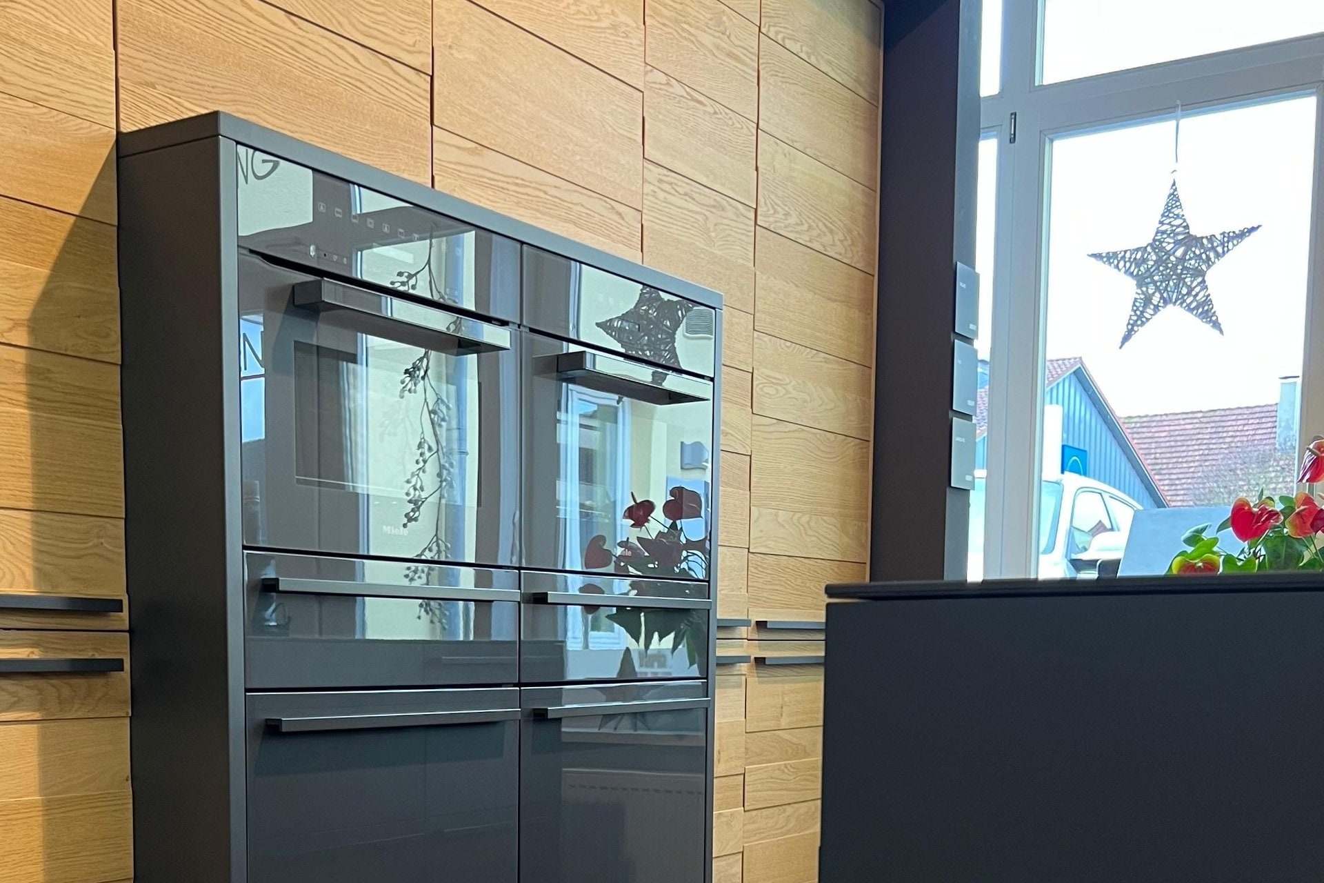 Ausstellung in Bad Staffelstein: Wand aus Eichenholz mit zwei Einbaubacköfen hinter Glas, rechts das Schaufenster
