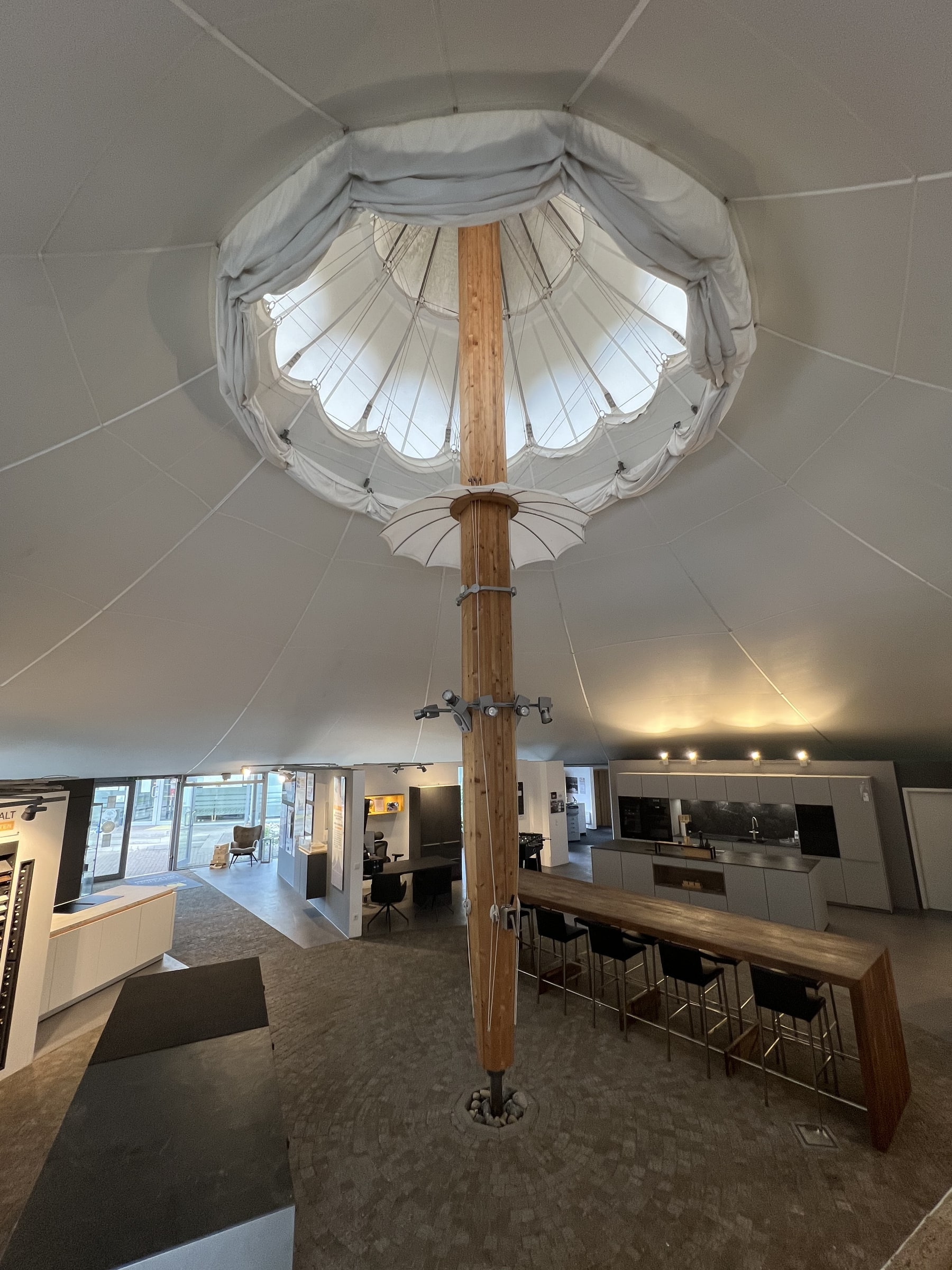 Blick nach oben in den Mast des Frei-Otto-Pavillons: Der Schirm öffnet sich unter der runden Dachlaterne, darunter die Ausstellung